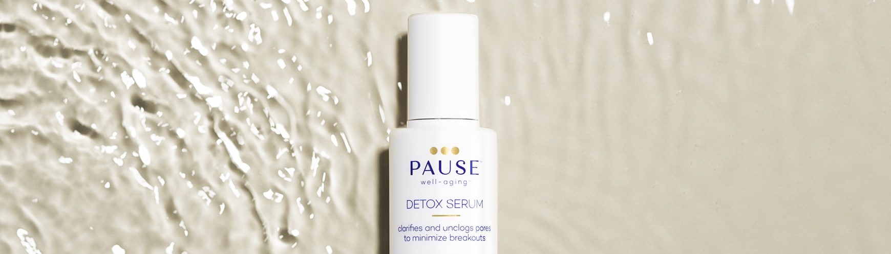 pause well-aging detox serum bottle lying in rippling water