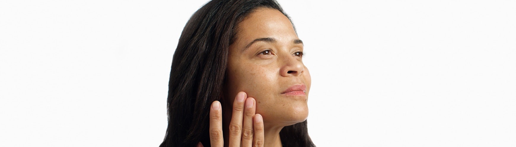 woman applying detox serum to her jaw line