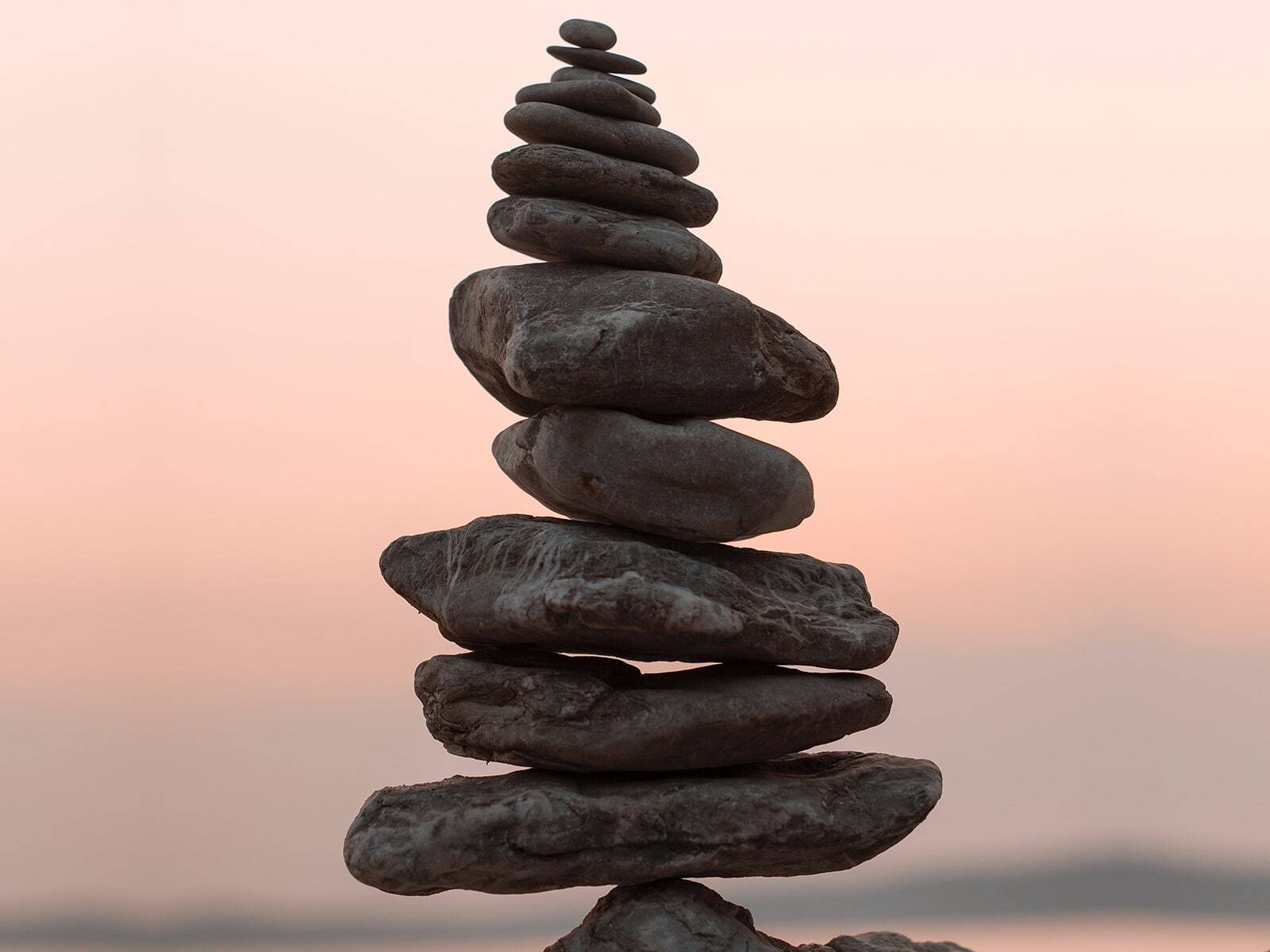 stack of balancing stones during a pink sunset
